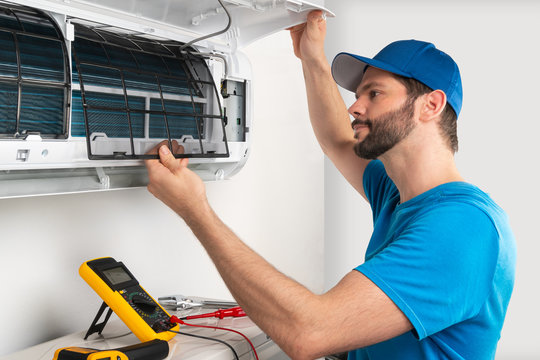 AC repair technician diagnosing fault on split AC unit in Delhi NCR — EZAC Service